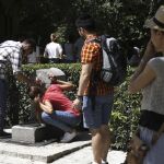 Varias personas se refrescan hoy en una fuente del parque del Retiro de Madrid