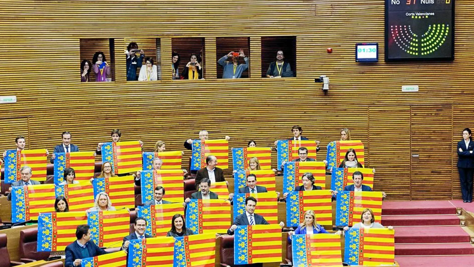 Los diputados populares sacaron senyeras cuando concluyó la votación. El resto del hemiciclo aplaudió.