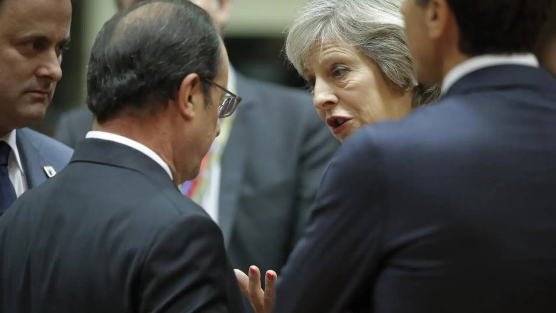 La primera ministra británica Theresa May conversa con el presidente francés François Hollande