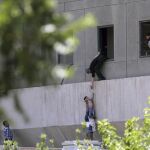Un policía pone a salvo a un niño tras la irrupción de los terroristas en el Parlamento iraní