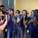 Un cliente aplaudido por los empleados de la Tienda Apple en Pekín tras comprar el primer iPhone