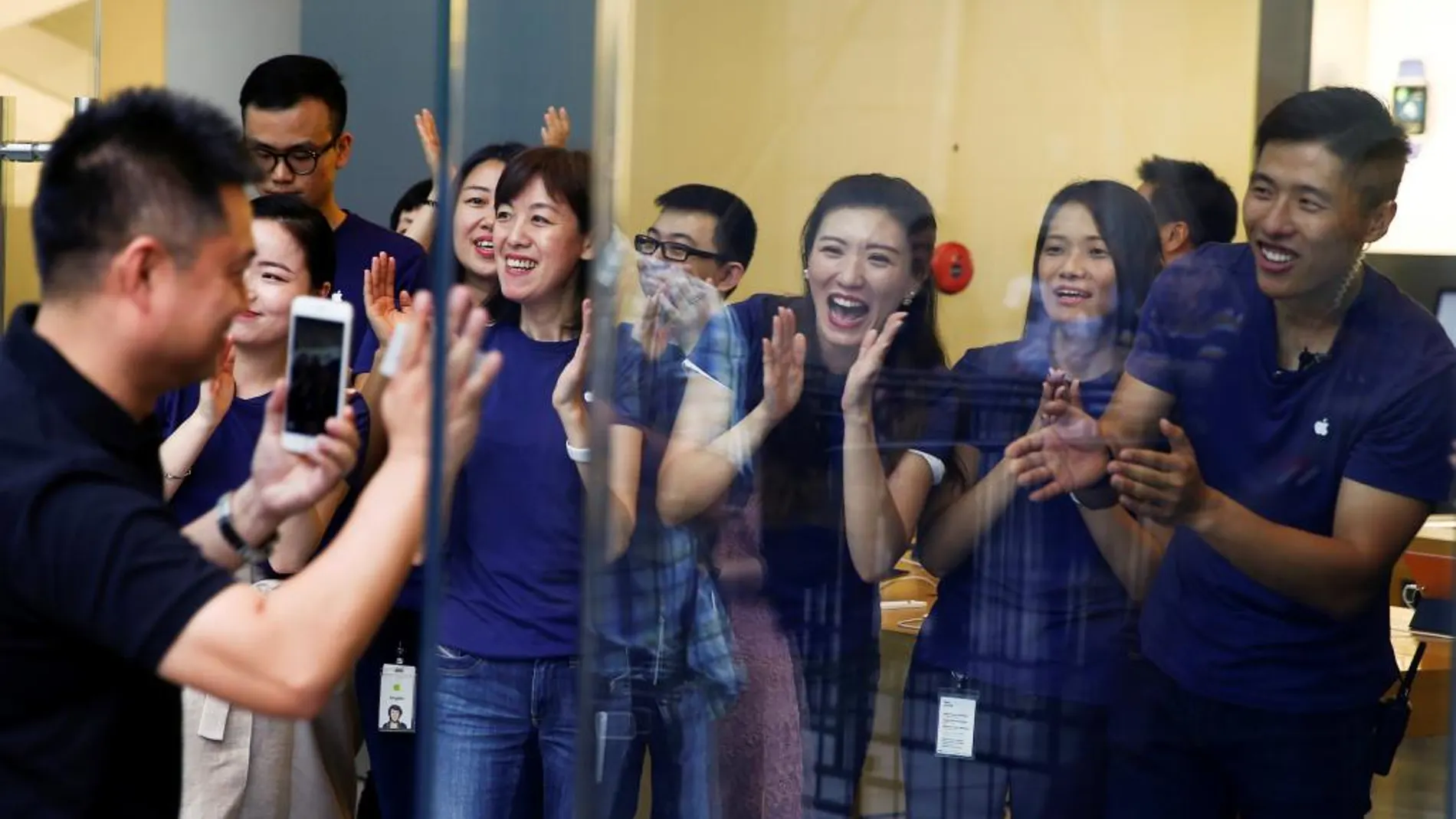 Un cliente aplaudido por los empleados de la Tienda Apple en Pekín tras comprar el primer iPhone