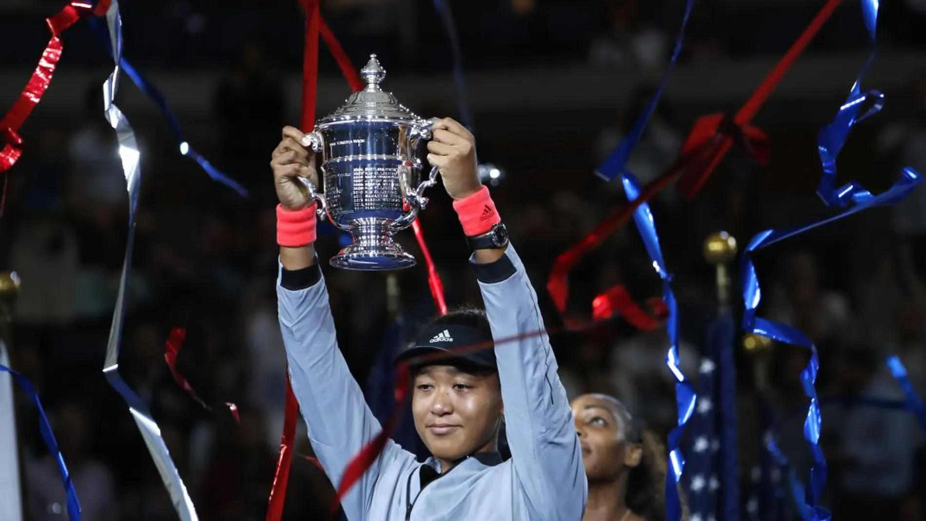 La tenista japonesa Naomi Osaka levanta su título como ganadora del Abierto de Estados Unidos en presencia de Serena Williams / Ap