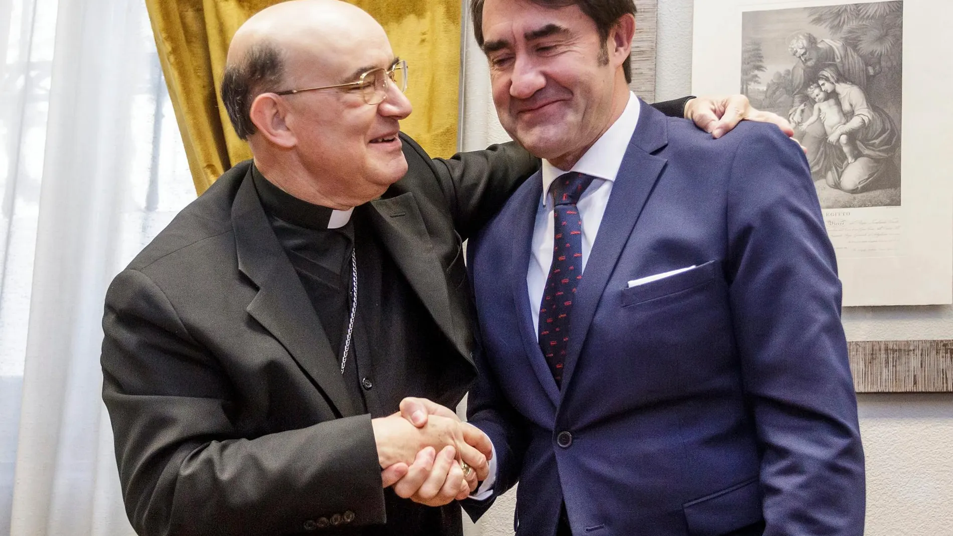 El consejero de Fomento y Medio Ambiente, Juan Carlos Suárez-Quiñones, estrecha la mano al arzobispo de Burgos, Fidel Herráez