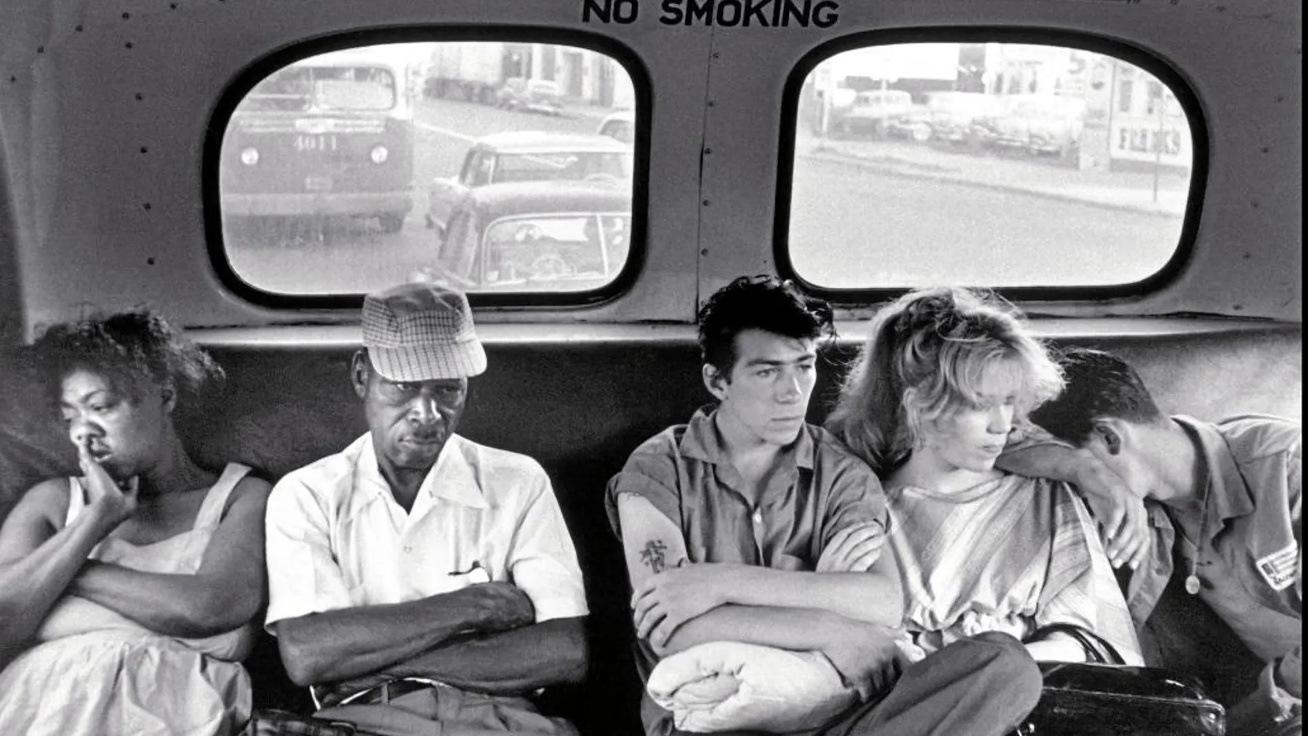 Unos pandilleros sentados en un autobús junto a una pareja negra