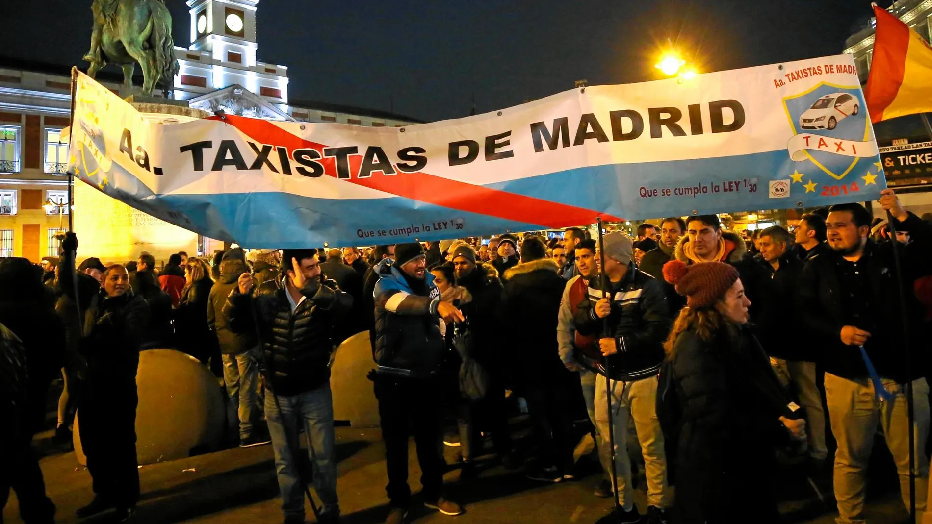 Los taxistas protestan con pancartas ante la sede de la Comunidad en la Puerta del Sol. Después del acto cortaron la Gran Vía para seguir con sus reivindicaciones