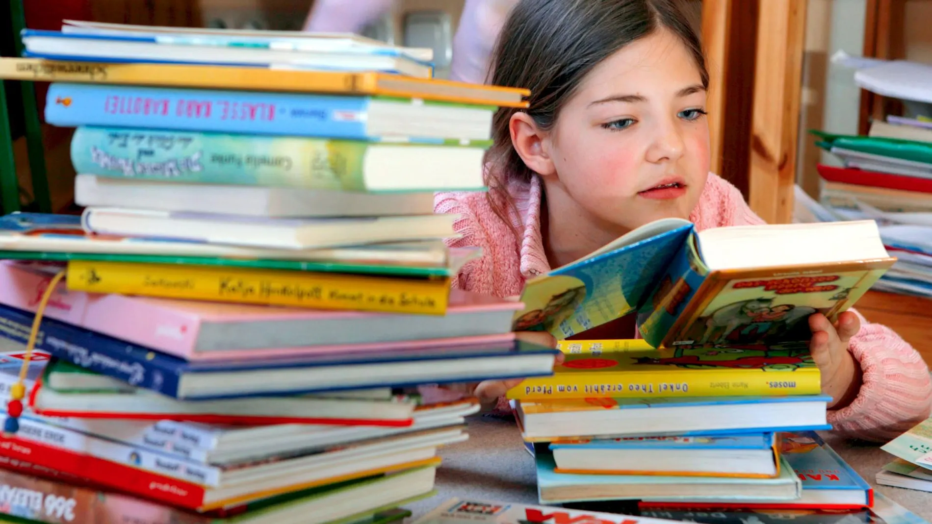 Una niña leyendo en una biblioteca
