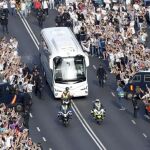 Aficionados del Real Madrid reciben el autobús que traslada a los jugadores al estadio Santiago Bernabéu.