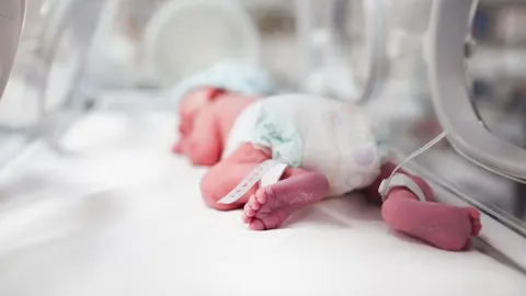 Un bebé prematuro en una incubadora