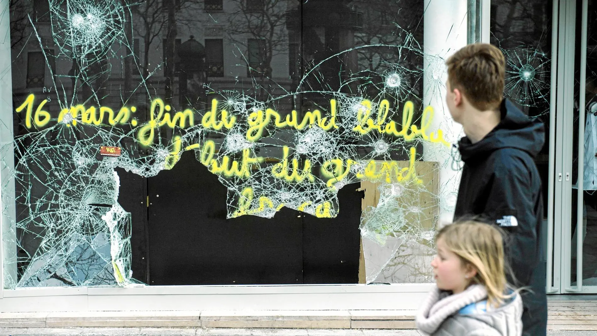 Varios parisinos contemplan ayer los destrozos en uno de los escaparates de los Campos Elíseos