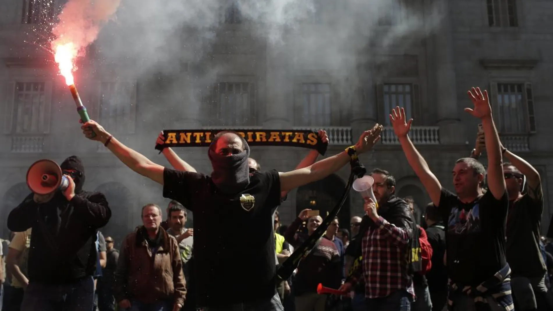 Los taxistas de Barcelona han lanzado bengalas, latas y botes de humo contra el Ayuntamiento de Barcelona