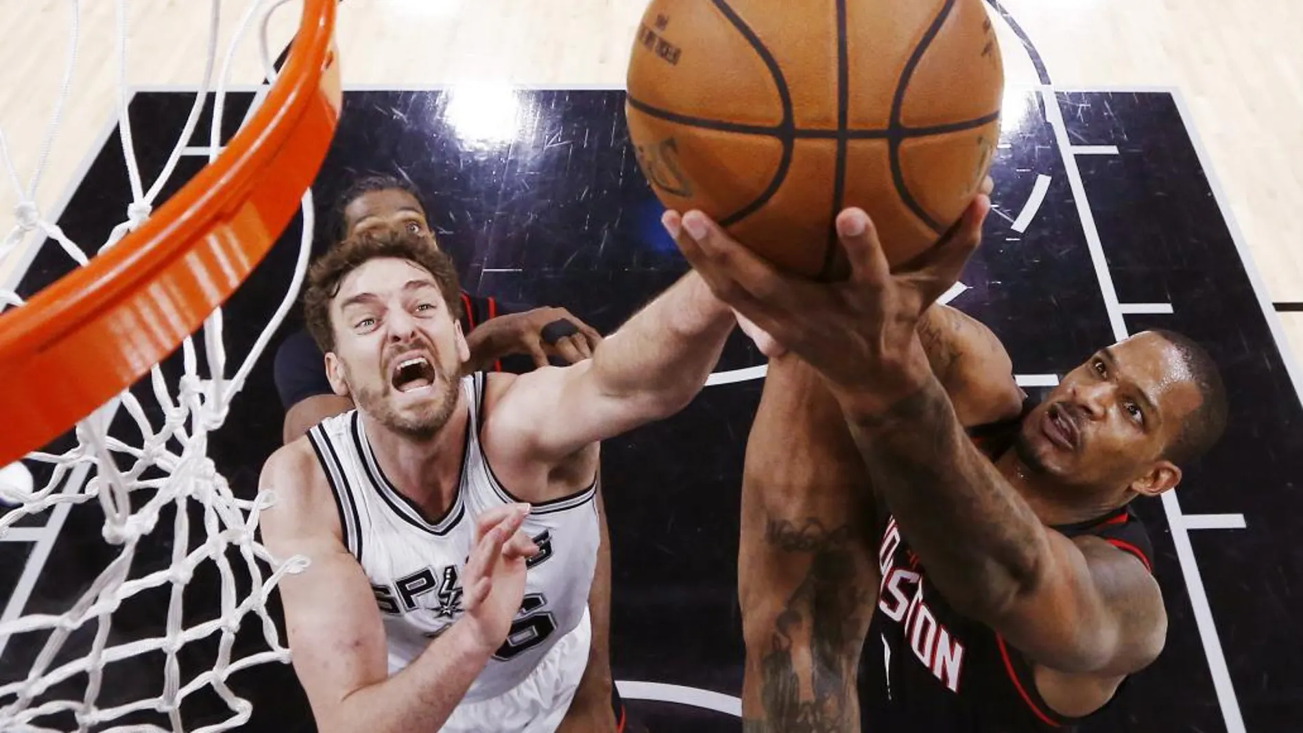 El jugador de Rockets Trevor Ariza (d) disputa el balón con el español Pau Gasol (i), de San Antonio Spurs, durante el partido