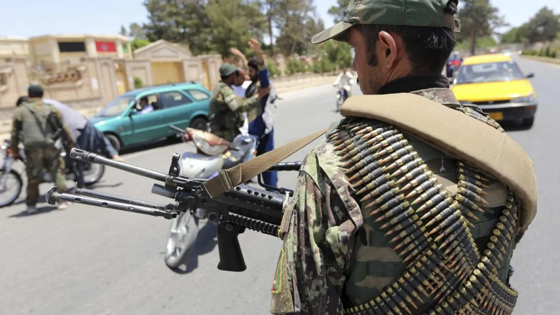 Agentes de seguridad afganos permanecen en guardia en una carretera tras el ataque suicida perpetrado ayer durante la hora del rezo contra una mezquita chií en Kabul