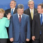 Merkel saluda a Cameron momentos antes de la foto oficial de la cumbre ante el líder ucraniano, Petro Poroshenko