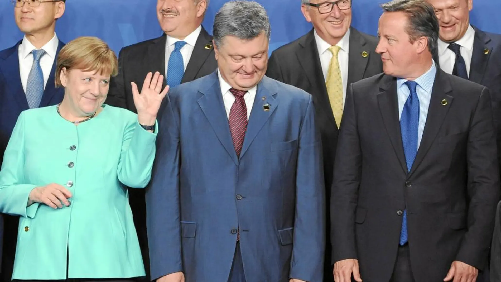 Merkel saluda a Cameron momentos antes de la foto oficial de la cumbre ante el líder ucraniano, Petro Poroshenko