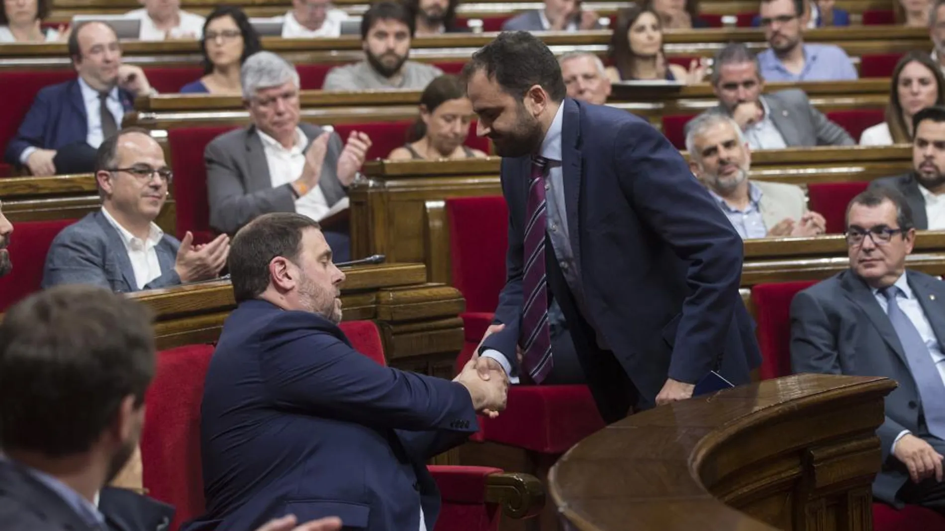 El diputado del PPC Fernando Sánchez Costa (d) saluda al vicepresidente del Govern, Oriol Junqueras (i) durante el pleno del Parlamento de Cataluña.