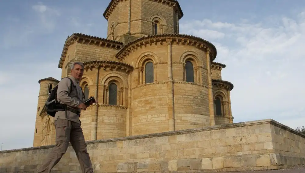 Un peregrino pasa por la Iglesia de San Martín de la localidad palentina de Frómista, en el Camino de Santiago, que se iluminará a partir de mañana