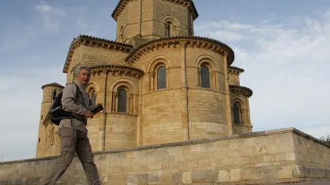 Un peregrino pasa por la Iglesia de San Martín de la localidad palentina de Frómista, en el Camino de Santiago, que se iluminará a partir de mañana