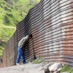 Un hombre observa a través de la verja con Estados Unidos desde Tijuana, la frontera de México