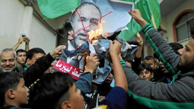 Un grupo de palestinos quema la imagen del dimitido ministro de Defensa, Avigdor Lieberman, en las calles de Gaza