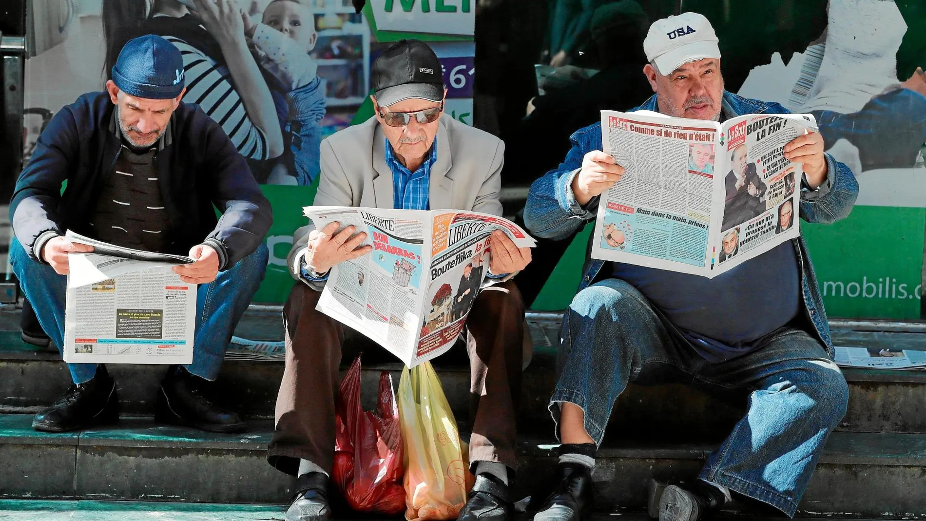 Varios hombres leyendo durante la jornada de ayer los periódicos que informaban sobre la renuncia del ya ex presidente Buteflika en Argel