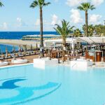 La piscina, de 4.000 metros cuadrados de agua salada, es el lugar obligado del club. Sobre estas líneas, detalle de alguno de los cócteles que pueden acompañar la comida en el restaurante Amaï