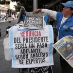 Una guatemalteca reparte periódicos frente al Palacio Nacional