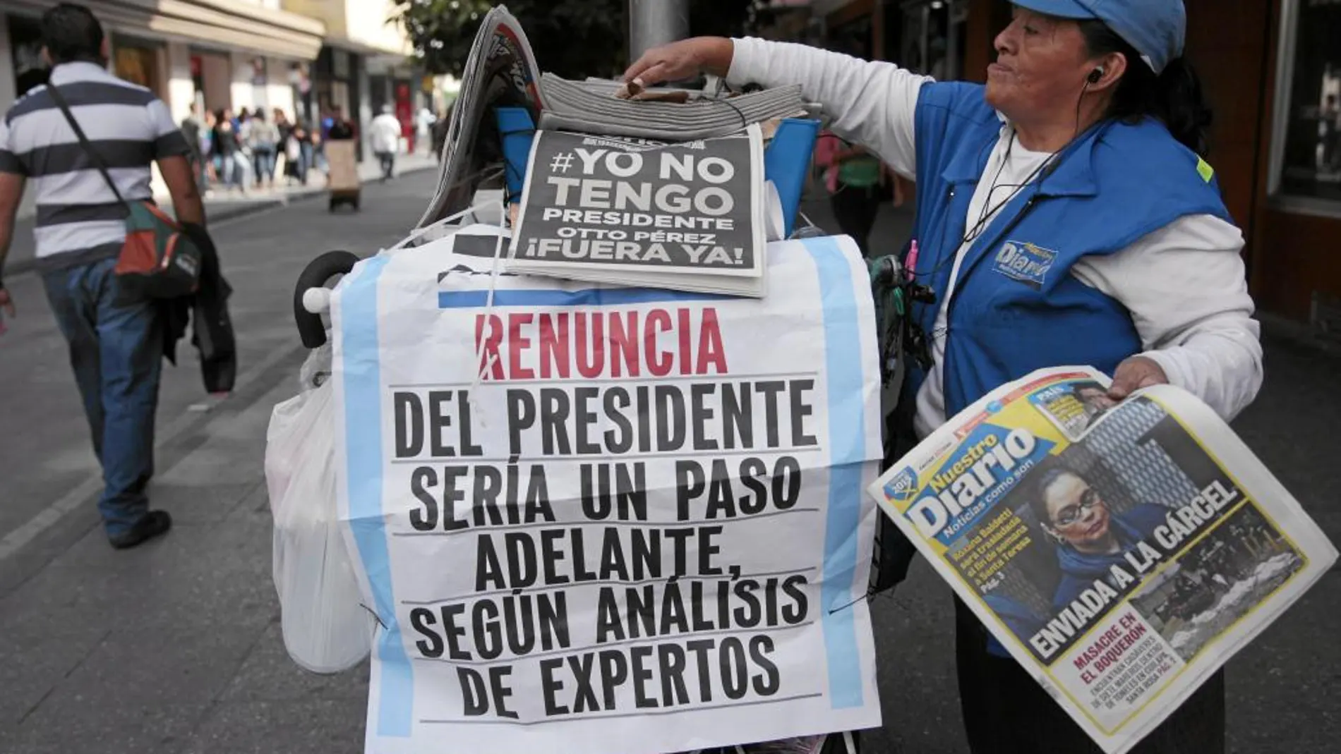 Una guatemalteca reparte periódicos frente al Palacio Nacional