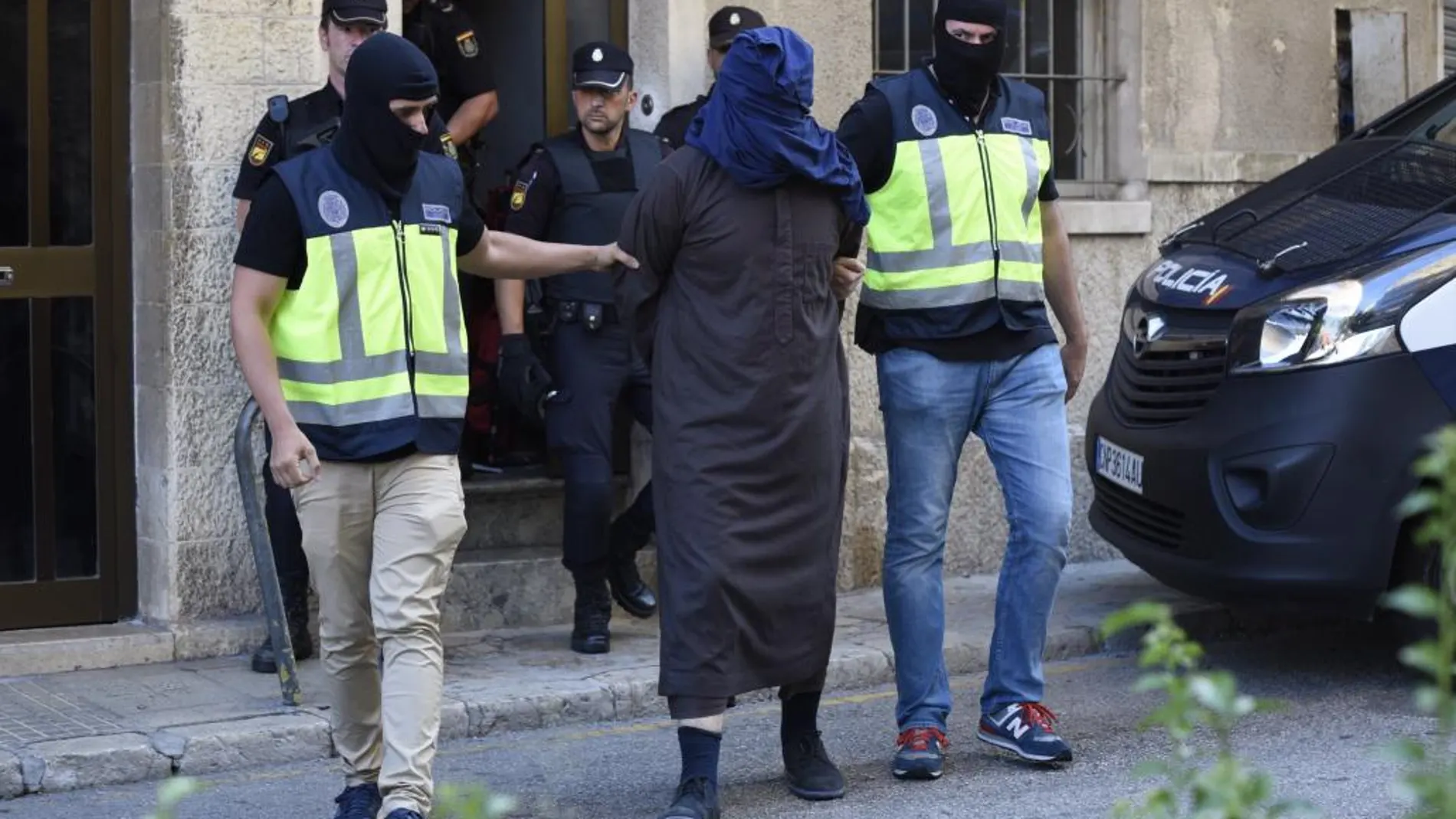 Efectivos de la Policía trasladan a un hombre detenido en la localidad de Inca (Mallorca), dentro de la operacióón anti yihadista desarrollada en la isla