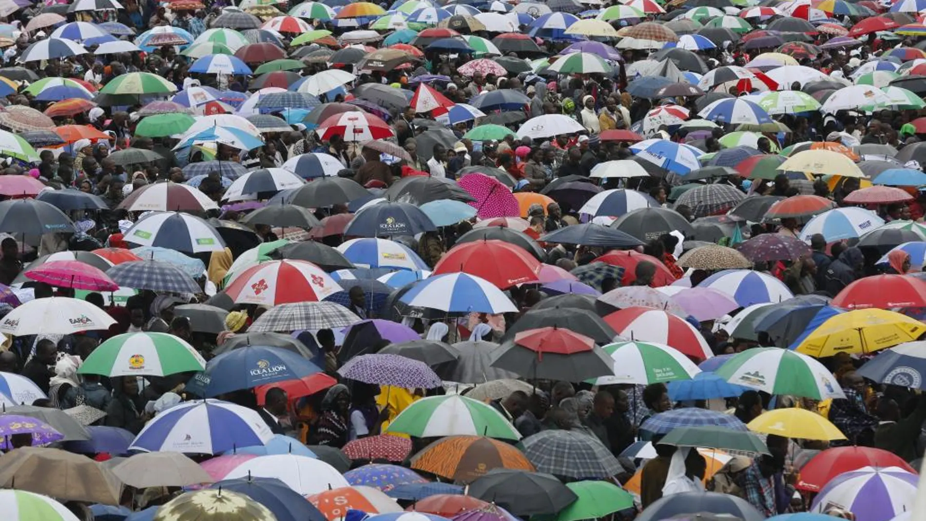 Miles de feligreses se cubren con paraguas durante la misa oficiada por el papa Francisco en el campus de la Universidad de Nairobi.