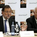 El presidente del Gobierno, Mariano Rajoy (i), durante la presentación del libro 'Todos los cielos conducen a España' del ministro de Asuntos Exteriores y Cooperación, José Manuel García-Margallo (d), hoy en Madrid