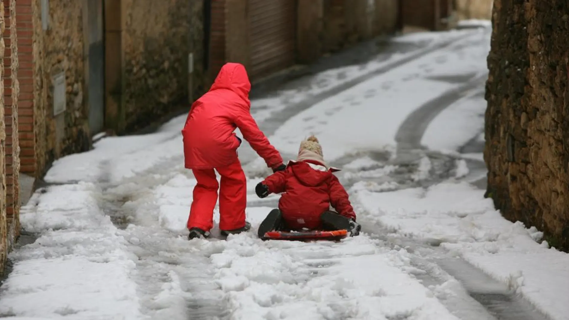 Dos niños en una calle de Vilanova de Prades (Tarragona) tras la nevada caída en la zona