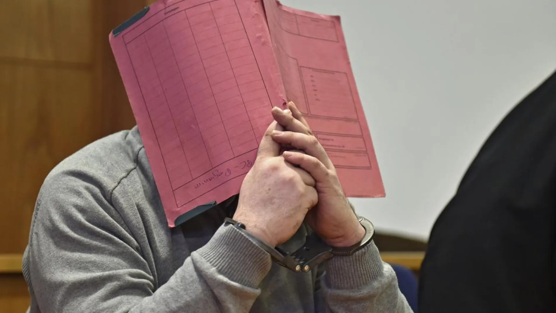 Foto de archivo de Niels H. mientras oculta su rostro mientras permanece sentado en el banquillo de los acusados durante una sesión de su juicio en Oldenburg (Alemania) el 26 de febrero de 2015.