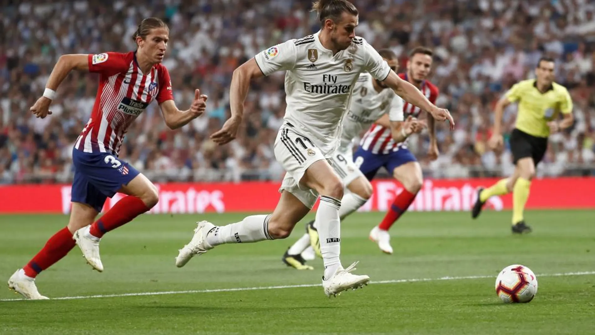 Gareth Bale conduce el balón ante el defensa brasileño del Atlético de Madrid, Filipe Luis. EFE / Mariscal.