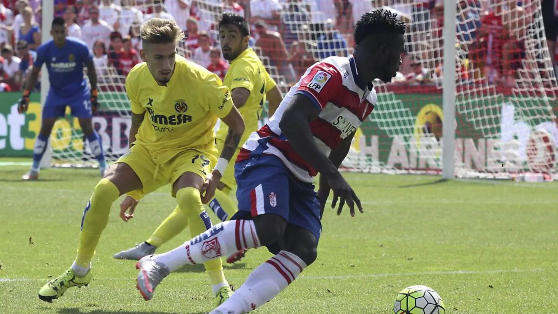 El delantero nigeriano del Granada Isaac Success (d), con el balón ante el centrocampista del Villarreal Samu Castillejo