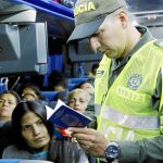 Un policía colombiano pide el pasaporte a los venezolanos que cruzan la frontera en Cúcuta