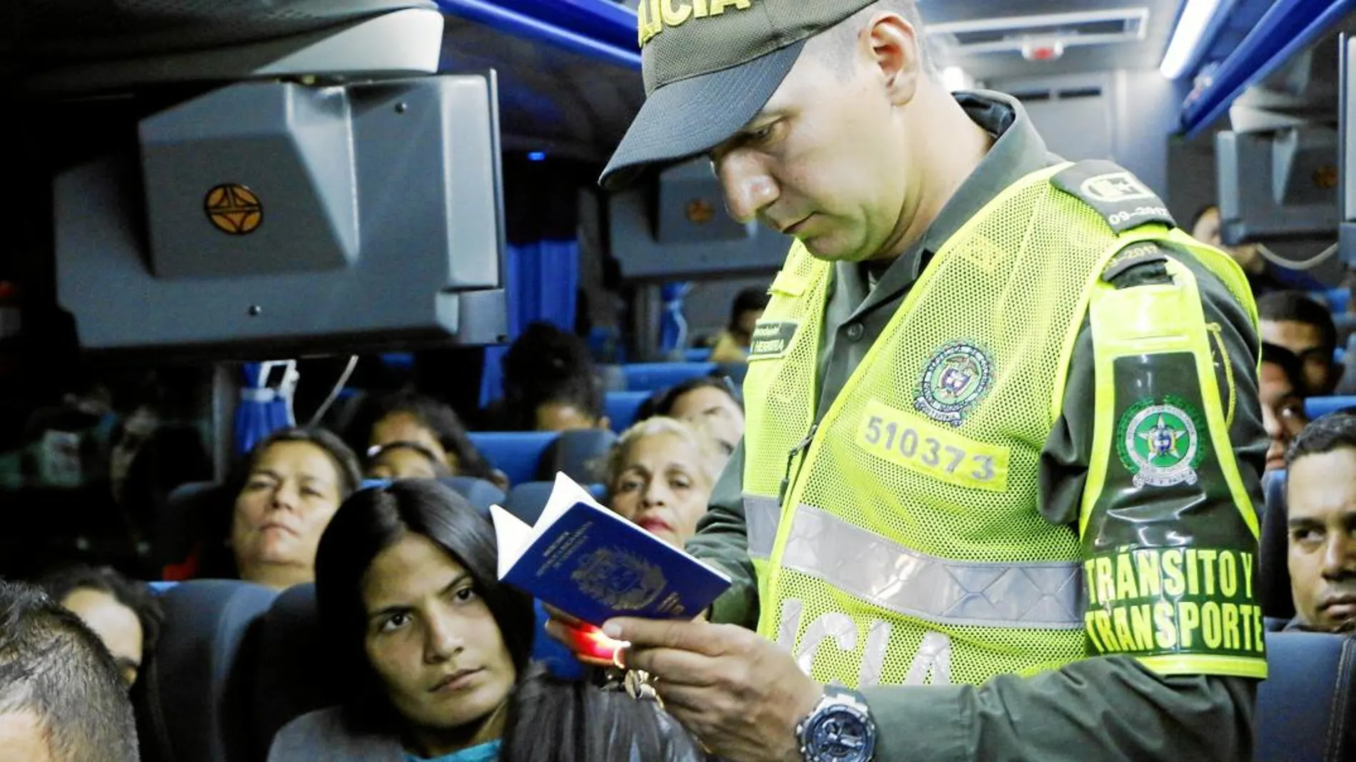 Un policía colombiano pide el pasaporte a los venezolanos que cruzan la frontera en Cúcuta