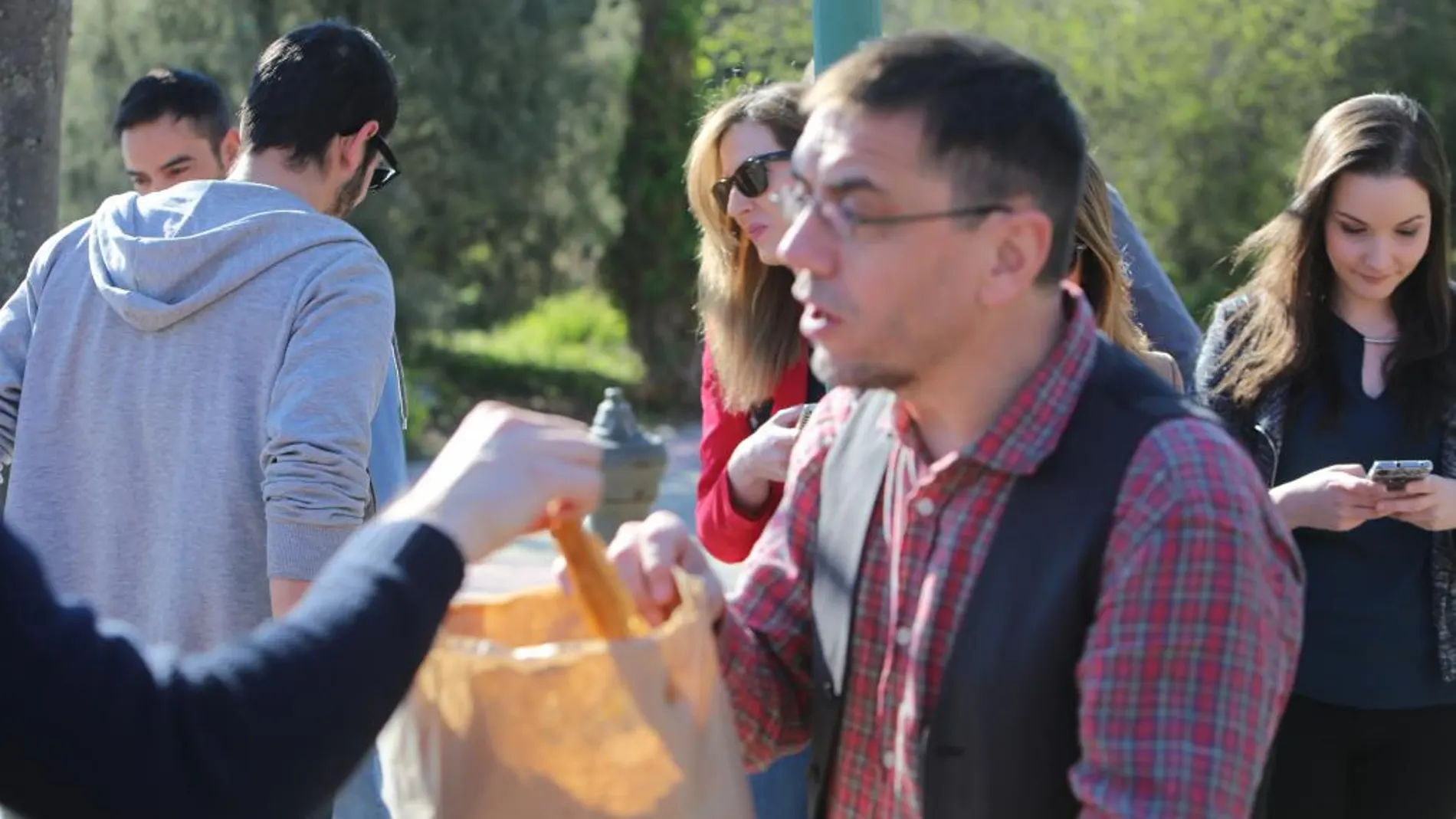 Juan Carlos Monedero, cofundador de Podemos, reparte porras de su barrio entre los cámaras y redactores