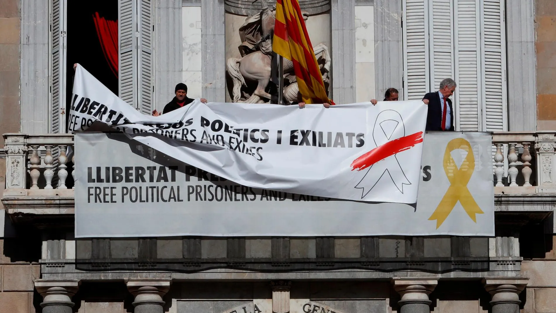 Sustitución de la pancarta a favor de los "presos políticos"del balcón del Palau de la Generalitat por otra con el mismo mensaje pero con un lazo blanco con franja roja.