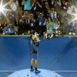 Djokovic se adjudicó el Abierto de Estados Unidos con autoridad ante un bravo Del Potro. El serbio besa el trofeo ante la petición de los fotógrafos / Foto: Efe
