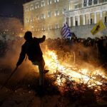 Ganaderos y agricultores queman ramas de olivos durante una manifestación, frente al Parlamento en Atenas