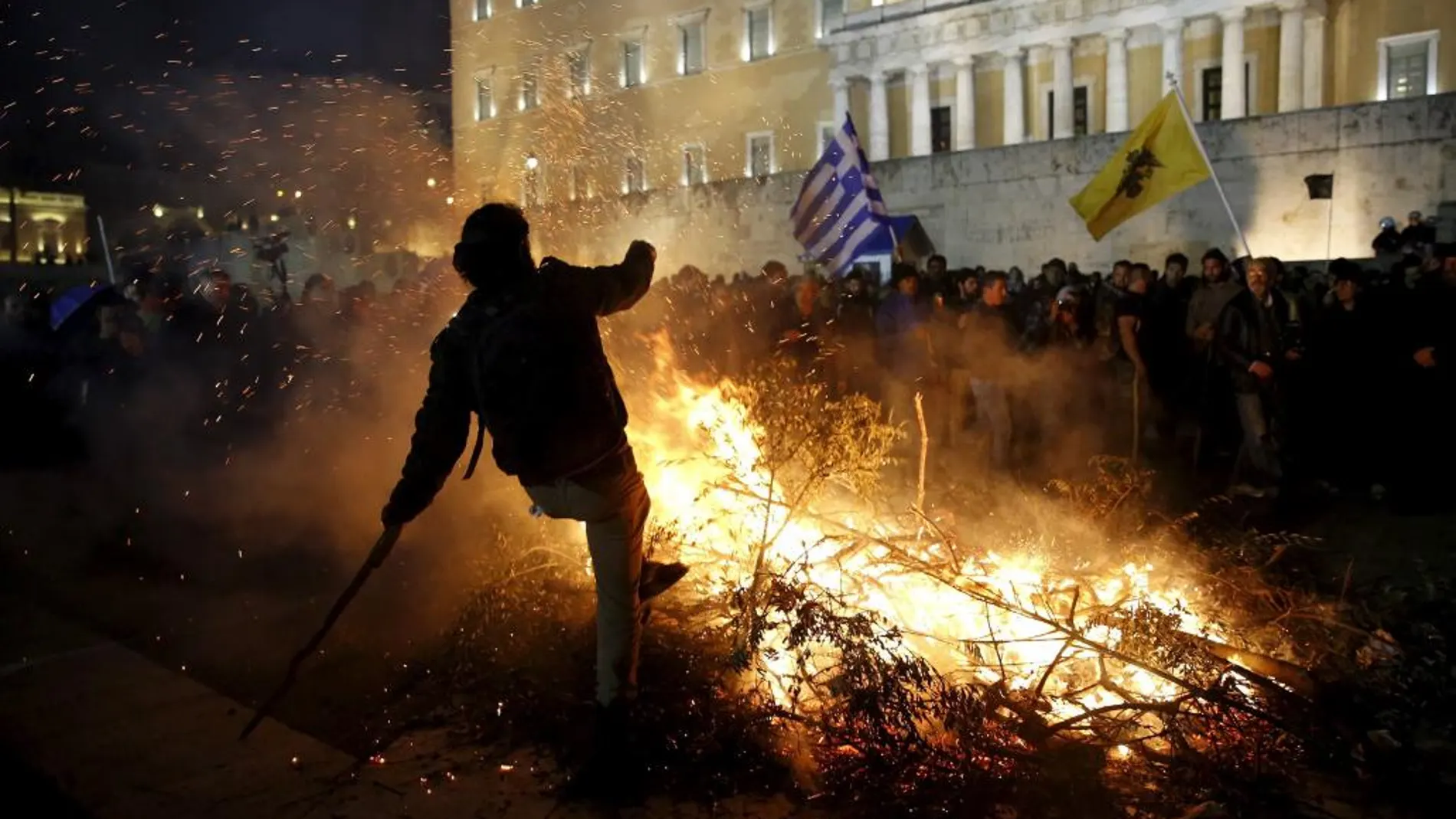 Ganaderos y agricultores queman ramas de olivos durante una manifestación, frente al Parlamento en Atenas