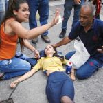 Represión policial. Una joven es auxiliada en Caracas tras ser afectada con gas lacrimógeno en una manifestación de protesta contra el Gobierno de Maduro