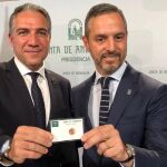 Elías Bendodo y Juan Bravo con la tarjeta con el céntimo que el consejero de Hacienda ha regalado a todo el Ejecutivo andaluz / Foto: EP