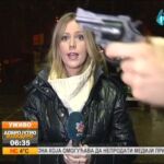 Un desconocido muestra una pistola a una reportera de televisión serbia en pleno directo
