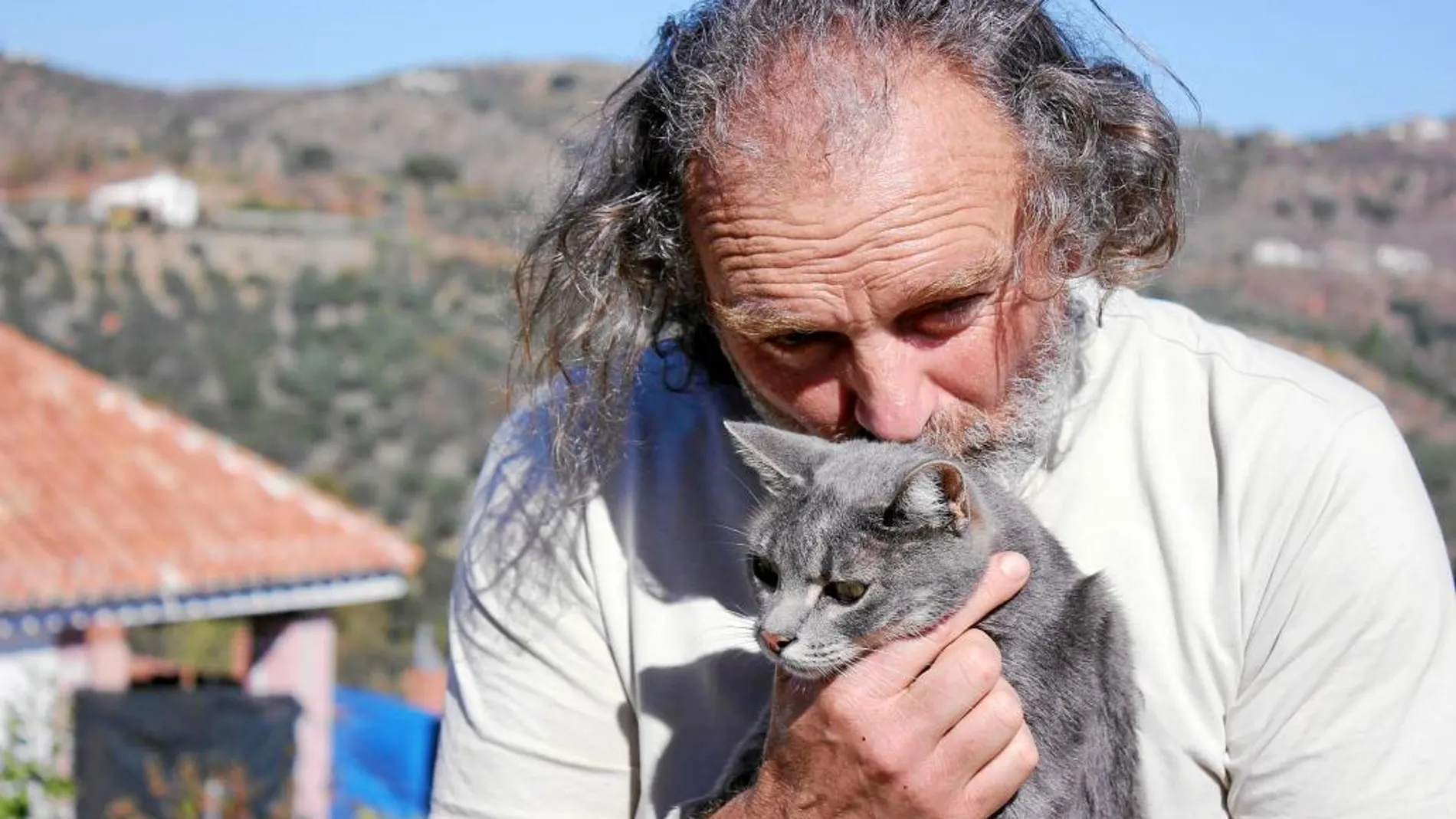 José Antonio Serrano, en su casa de Monda, con uno de los gatos de su protectora