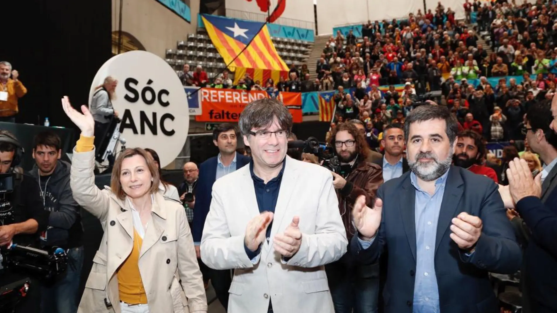 El presidente de la Generalitat, Carles Puigdemont (c), junto al presidente de la entidad soberanista, Jordi Sánchez (d), y la presidenta del Parlament, Carme Forcadell (i), durante la clausura hoy de la asamblea general de la ANC
