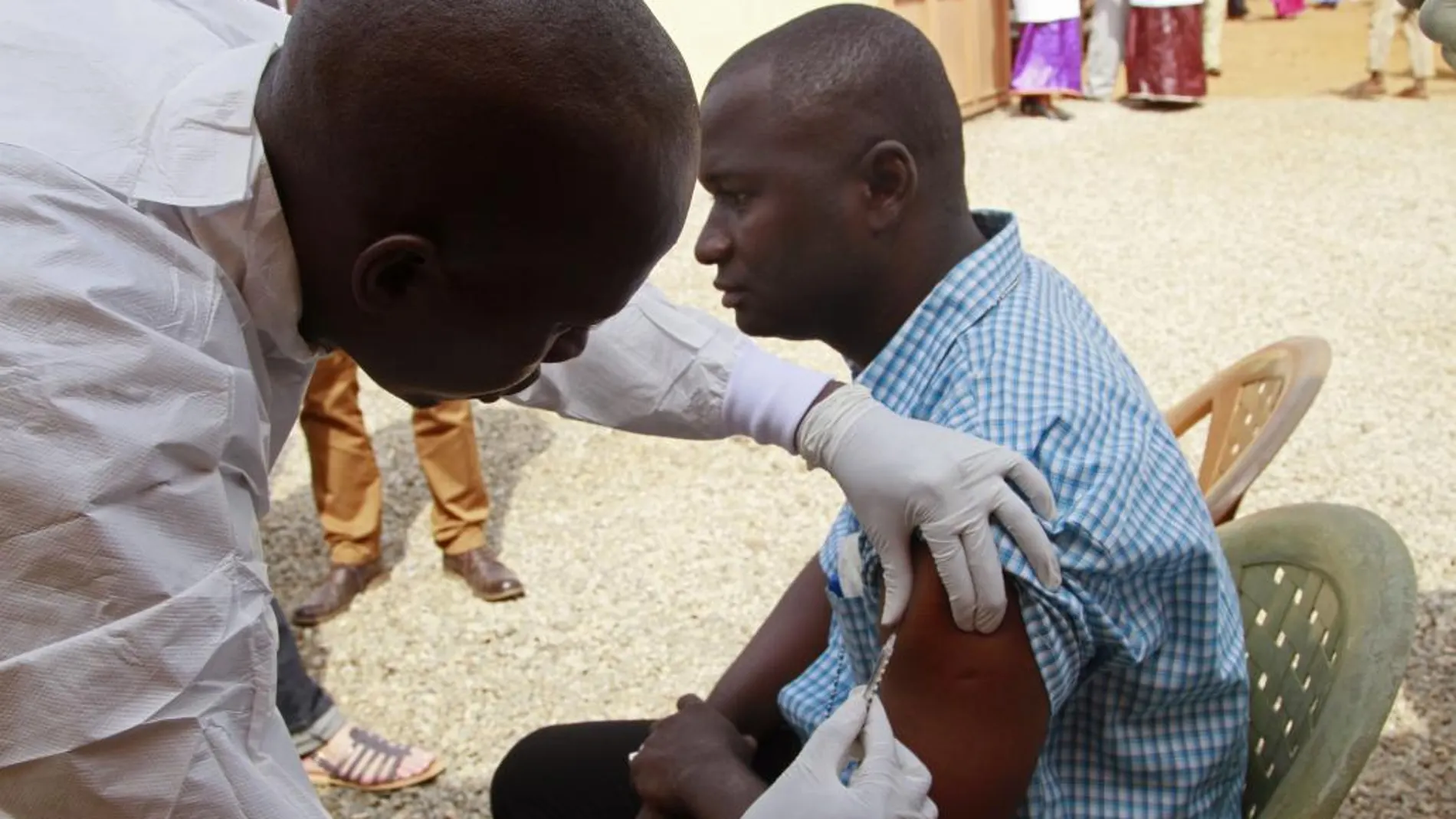 Un sanitario vacuna a un hombre en Guinea Conakry