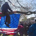 Un hombre sentado sobre la rama de un árbol contempla la iglesia de San José, donde se celebró ayer el funeral por una de las víctimas del atentado de Boston