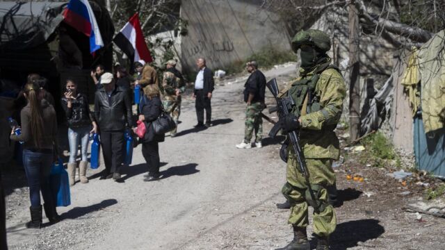Un soldado ruso ayuda a la población de Ghunaymiyah.